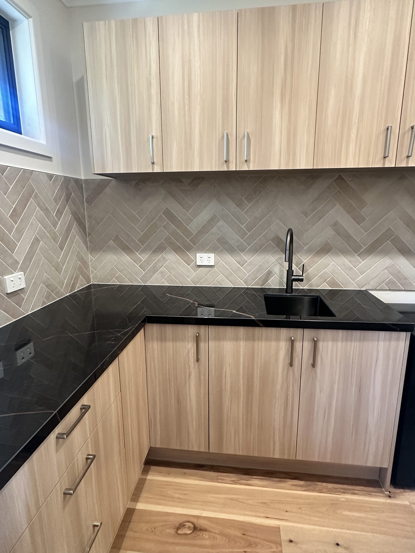 Stone benchtop kitchen with dark cabinetry